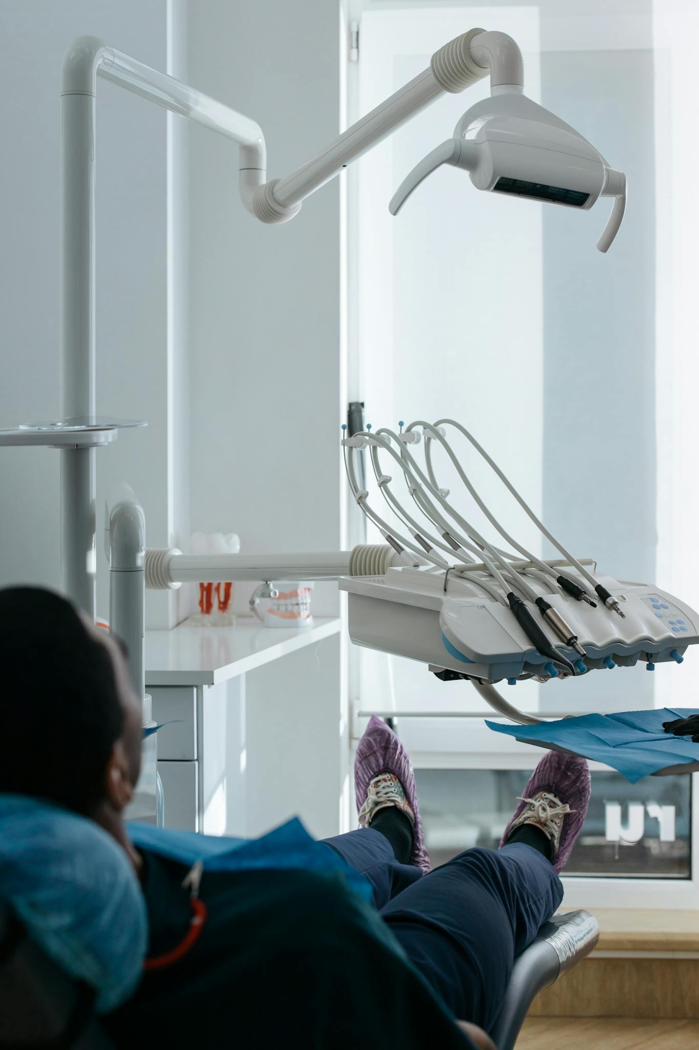 A patient seated in a dental chair at a modern dental clinic, showcasing equipment.